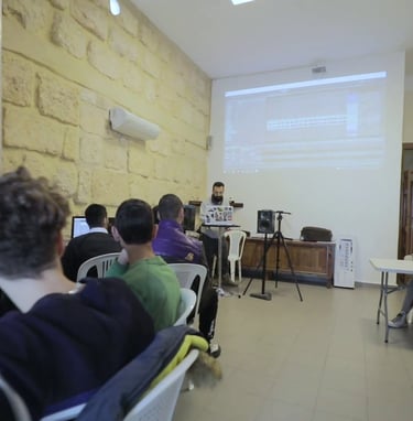 a group of people sitting at tables in a room in a workshop given by beatlalipos in lebanon