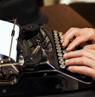 Se ven las manos de una persona escribiendo en una máquina de escribir