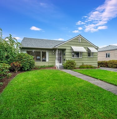 a house with a green lawn and a small house