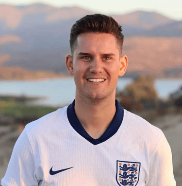 Portrait of a person wearing an England football shirt, smiling towards the camera outdoors
