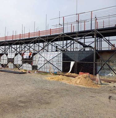 SWEN Construction workers installing decorative facade panels on a steel scaffolding structure.