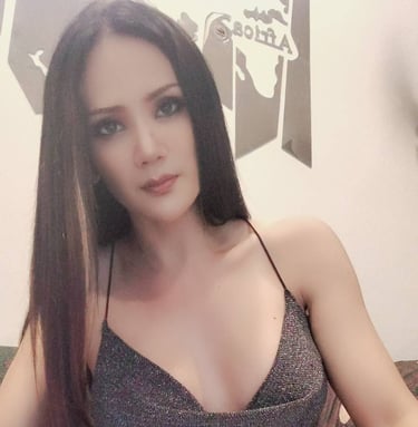 Ladyboy wearing a low cut short brown dress