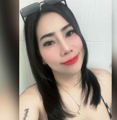 Half body shot of a lady wearing a black and white low cut top and sun glasses on her head.