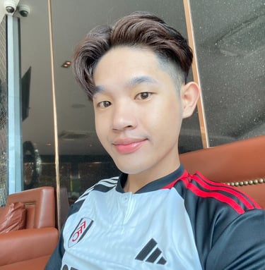 Thai male masseur sitting on a chair wearing a blue sports t-shirt.