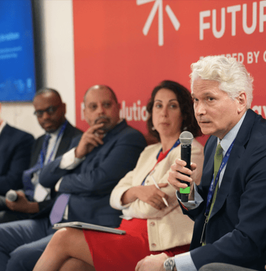 COP climate conference event with speakers giving presentation.