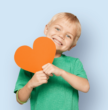 Young boy holding heart for support of an organ donation campaign.
