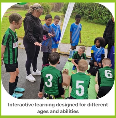 A group of boys in football kits around in a circle with an instructor learning first aid