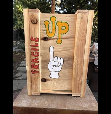 Shipping crate for Talbotics sculpture with image of hand pointing up drawn on it.