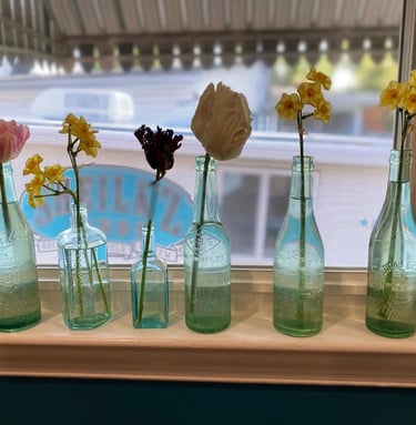 a row of glass bottles with flowers in them