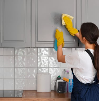 KLEAN WELL team member carefully wiping kitchen cabinet to deliver expert, spotless results