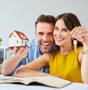 a man and woman holding keys to a house