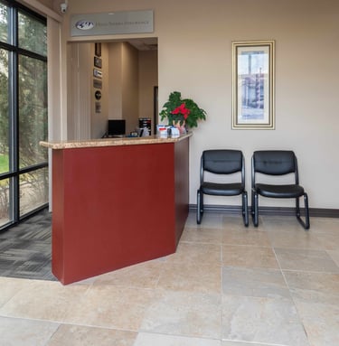 a reception desk with two chairs and a desk