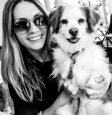 Black-and-white photograph of me, a pet photographer, hugging my dog Crika. We are close together, s