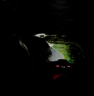 a car driving down a dark road in the dark