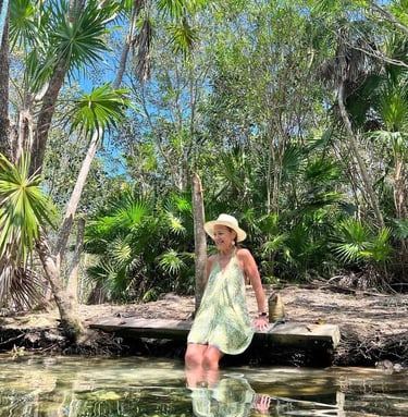 a woman in a dress and hat at a cenote at a retreat in Mexico
