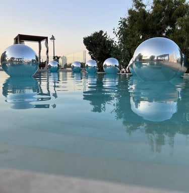 Elegant silver balloons floating beautifully above a luxurious poolside wedding in Santorini