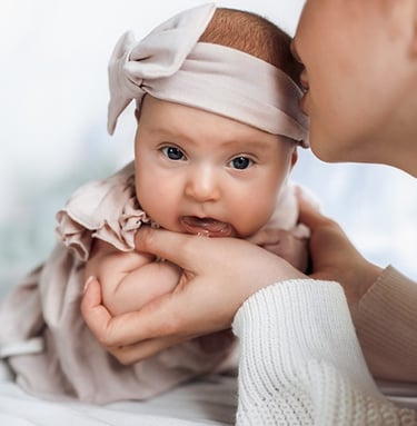 a baby girl in a pink dress and a woman in a white dress