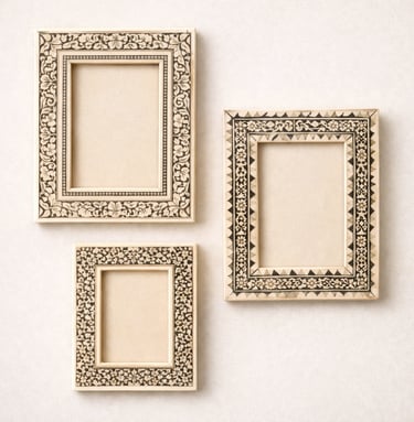 Bone photo frames with floral inlay designs and carved borders.