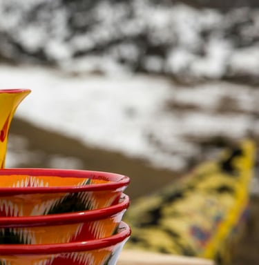 red and yellow ceramic teapot on red textile by Daniel Fox