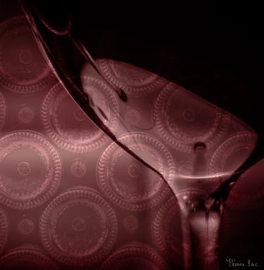 Verre de vin devant une pile de cul de bouteilles de vin en cave