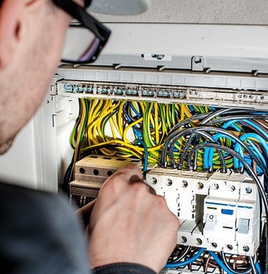 Electricien intervenant sur un tableau électrique