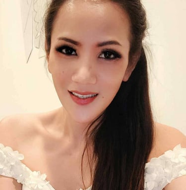 Ladyboy wearing a frilly of the shoulder white dress