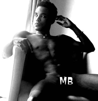 A man sat in the nude on an armchair but with the letters MB covering his private parts