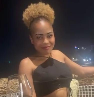 Lady sat outside in the evening with a glass of wine on table