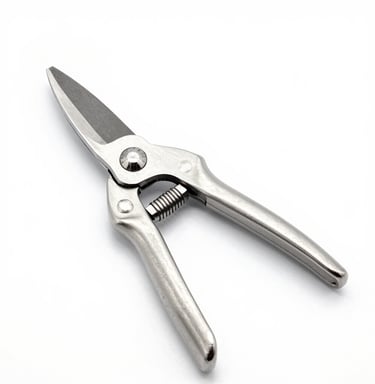Close-up of a sharp pruning shear resting on freshly cut branches with green leaves.