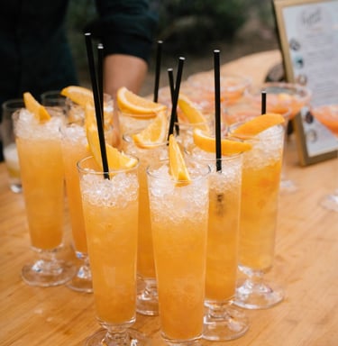 Refreshing orange cocktails with crushed ice and citrus slices at an outdoor bar.