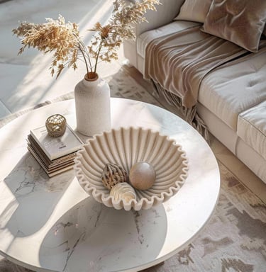Modern living room marble coffee table with a fluted bowl, pampas grass in a ceramic vase, and books.