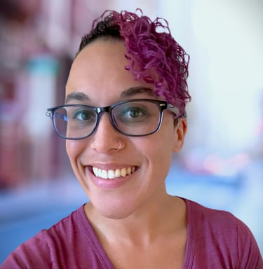 a woman with glasses and a purple shirt