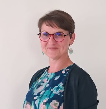 Photographie d'Emmanuelle, Gestalt Thérapeute. Femme chatain aux cheveux courts et lunettes