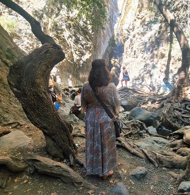 a woman in a dress looking at a Platres waterfall during a Cyprus nature photography tour