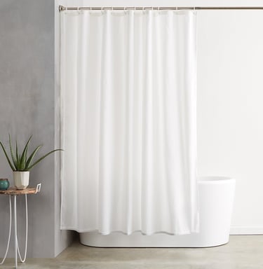 a white shower curtain with a plant in a bathroom