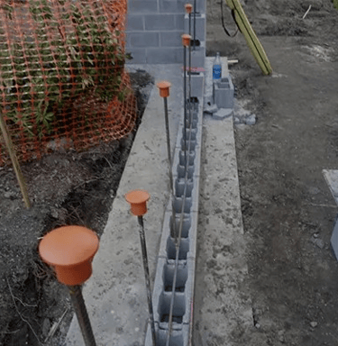 a concrete block structure with orange plastic caps and orange plastic caps