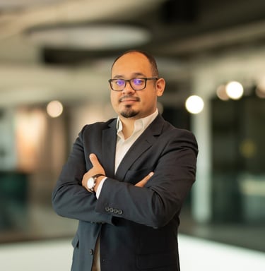 a man in a suit and glasses standing in a room