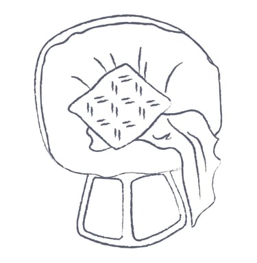 a chair with a pillow and draped blanket on it