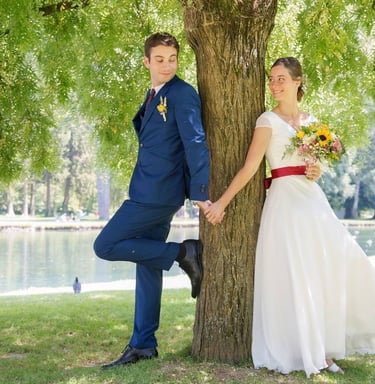 photo de couple de mariés dos à dos contre un arbre dans un cadre verdoyant