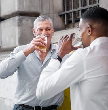 gay sugar daddy and sugar baby are drinking beer and networking outside a city pub.