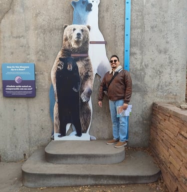 Luis standing next to a trio of bear cutoffs to compare his height.