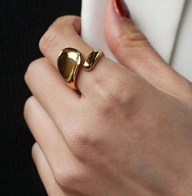 Mujer elegante que luce un anillo de oro grueso con un diseño escultural orgánico y moderno.