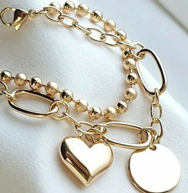 Elegante pulsera con dije de corazón y colgante de disco circular en una cadena de eslabones
