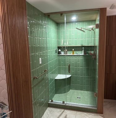 Modern bathroom featuring green subway tiles, wood slat walls, and a glass walk-in shower.