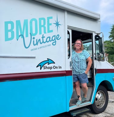 Shop owner standing in the door of a blue and white truck