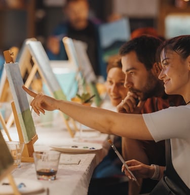 a man and woman are looking at a painting