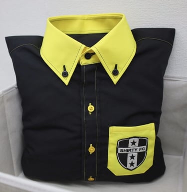 a black pillow designed as shirt with yellow collar and pocket