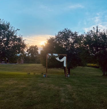 wedding arbor in a meadow at sunset
