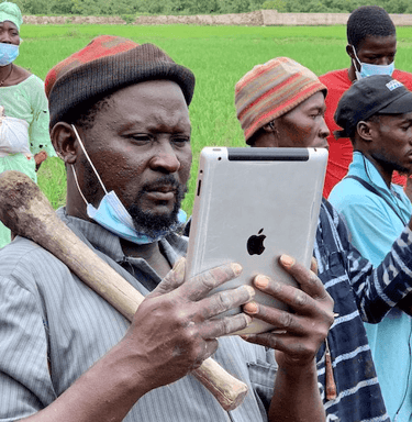 Homme avec chapeau utilisant une tablette pour agriculture durable en Afrique