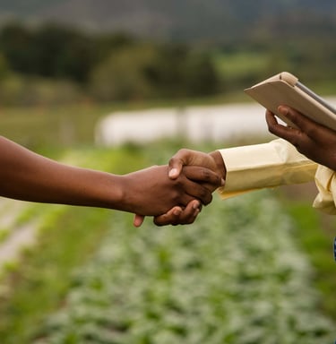 Homme et femme serrant la main dans un champ, partenariat agricole durable en Afrique